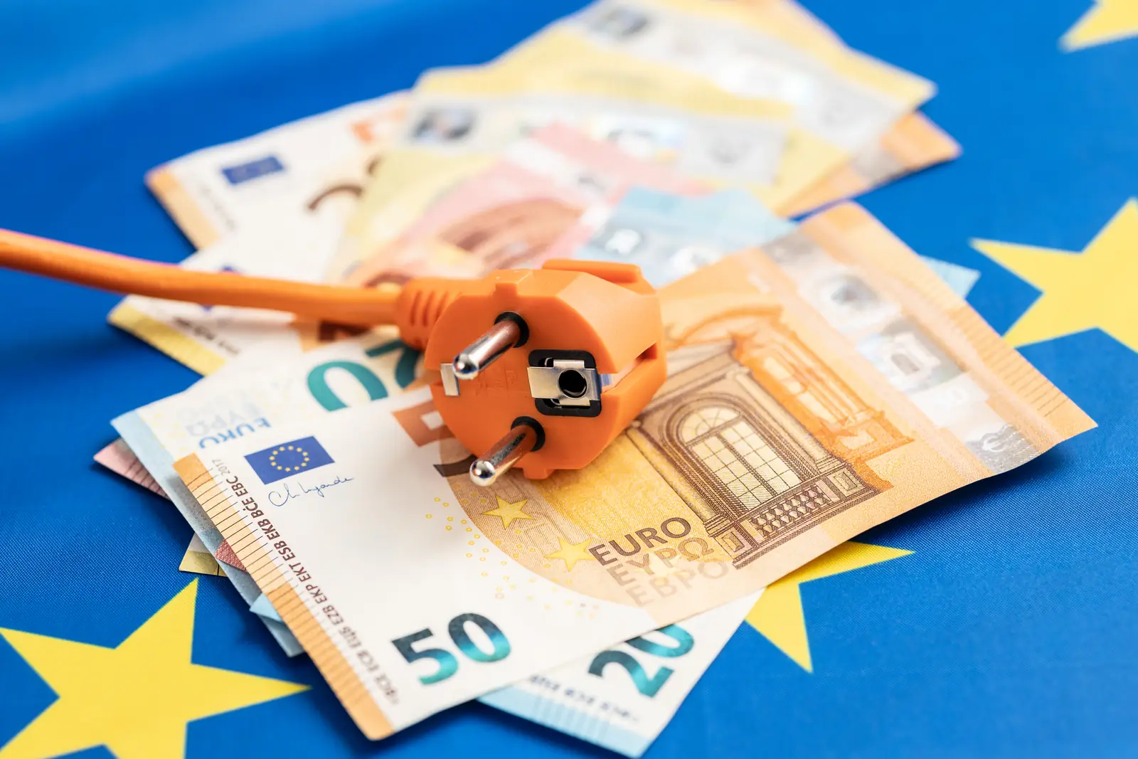 Elektrostecker auf Euro-Banknoten als Symbol für Energiekosten