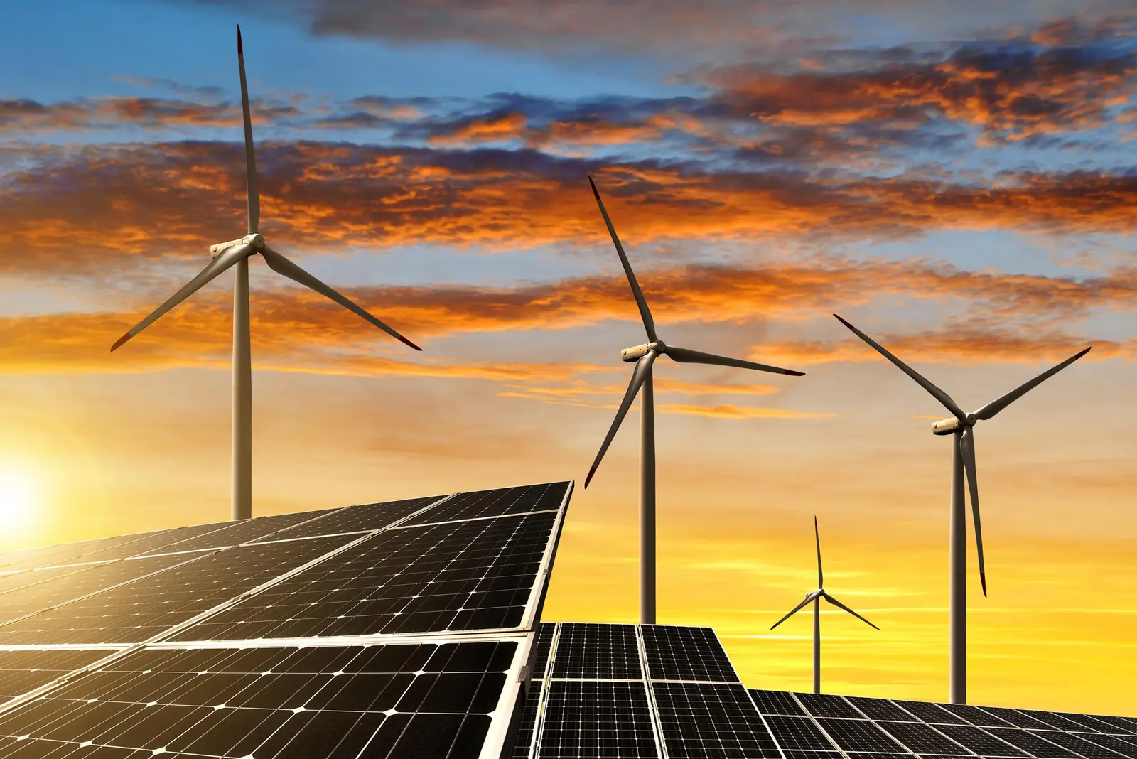 Solarmodule und Windkraftanlagen bei Sonnenuntergang
